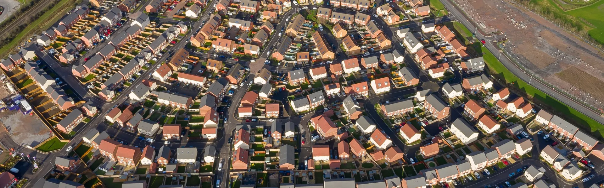 Aerial view of a large residential housing development with multiple homes and road layout